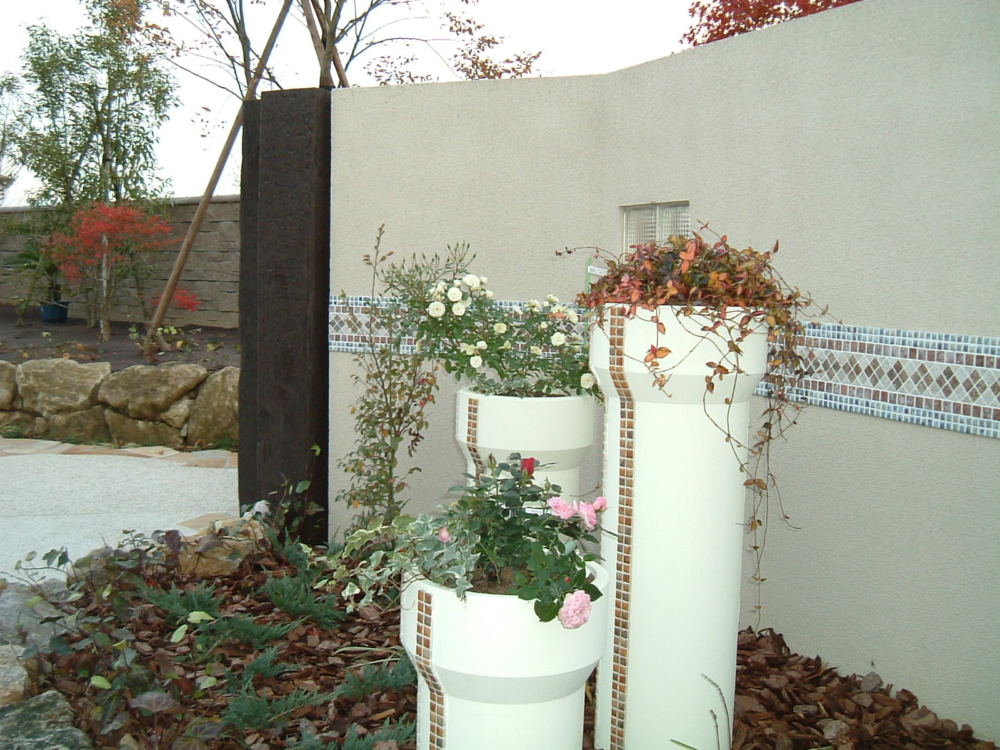 門柱を彩る植栽。タイルがアクセントです。横に広がる壁に縦のラインのタイルと植栽が奥行きと広がりを出します。