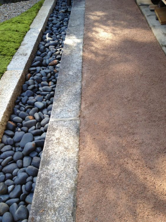 焼き物のリサイクル舗装{「やきもの散歩道」で土間を作りました。雨落ちの排水路には特大の那智黒石を敷き詰めました。