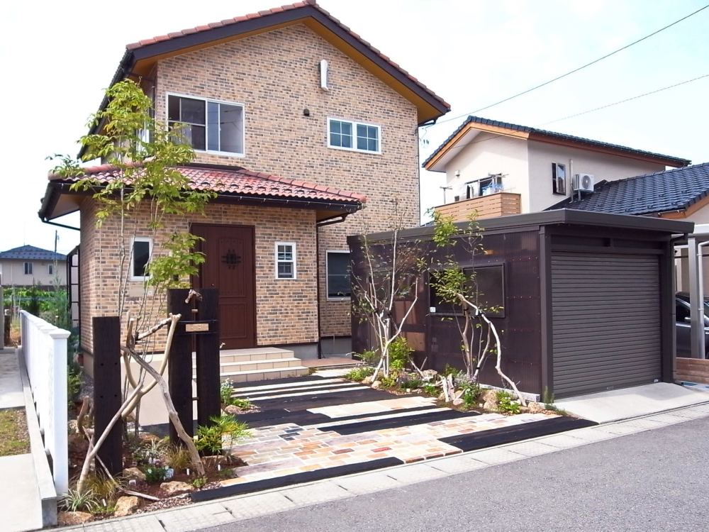 アプローチと駐車場を兼ねたお庭に生まれ変わりました！

車が駐車していないときもおしゃれな雰囲気が道行く人の目をひきます。
枕木の門柱とシンボルツリーのアオダモの株立ちがアクセントのおしゃれなファザードになりました。
