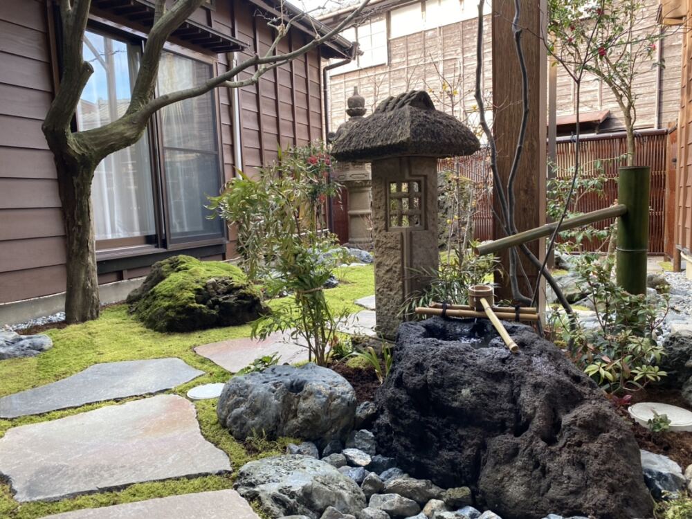 自然石の水鉢と出雲灯籠(小屋棒)。