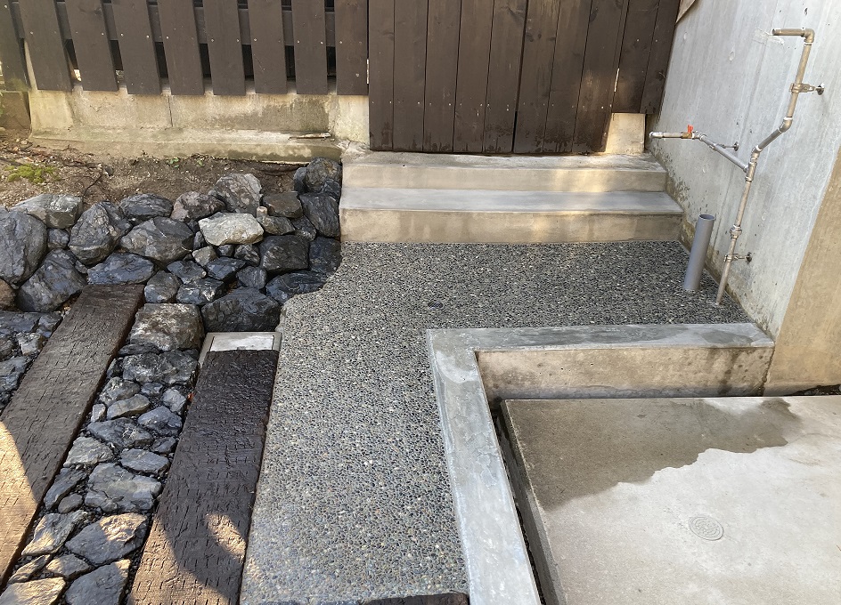 水が溜まる建物側に排水桝を設置。また庭仕事をした後にガレージに泥が入らない様、靴の泥を落とす靴洗い場を洗い出しで施工。お施主様が水道脇にガーデンパンを取り付けられるそうです。