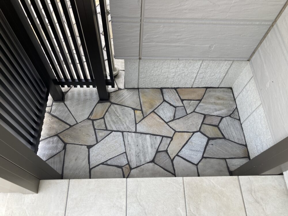 ポーチ周りから続く石張りに。見た目も美しく、鉢植えや道具を置いて汚れてもデッキブラシで洗い流すなど使い勝手も良くなりました。