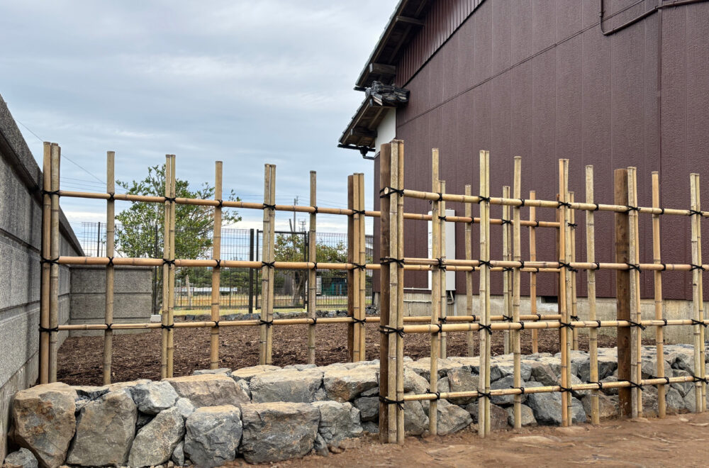 主庭から少し高くなっている裏庭のドッグランへのフェンス入り口へは、石組みで段差を付けた四ツ目垣を抜けていく。