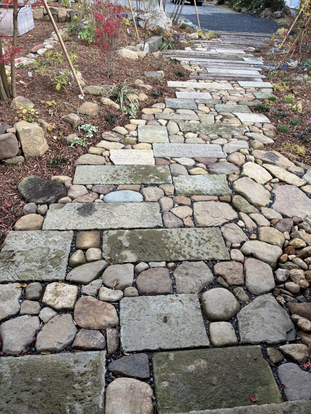 大谷石と土地から出てきた石を組み合わせて出来た風情のある石畳み。奥の枕木のアプローチへと続きます。