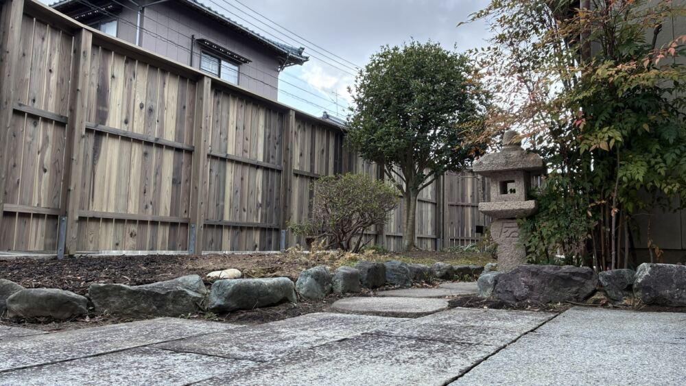 お庭の内側(敷地内)から見ても、板塀の温かみのある木肌が、大切にされてきた既存の灯篭や美しい庭木を引き立てる上質な背景となっています。
生垣を撤去した足元もすっきりと整理され、眺めてホッとする心地よいプライベートガーデンに生まれ変わりました。