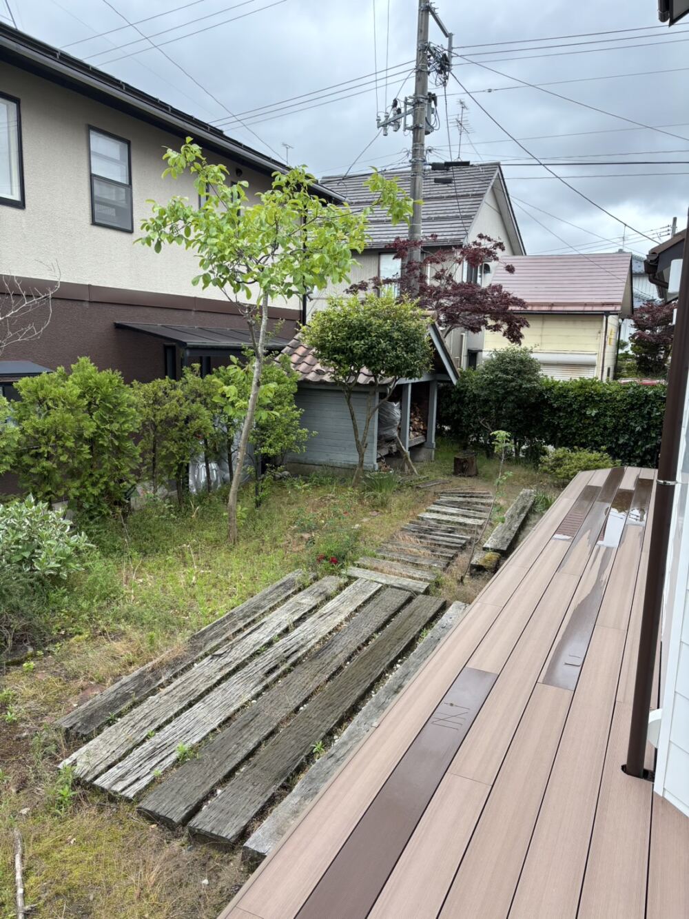 以前は奥に見える水色の薪小屋のみでした。
中古住宅をリフォームされて素敵な新生活が始まっていましたが、お庭のこれからのライフスタイルや、
新しくなったお住まいの景観に対して、サイズ感や全体のデザインの調和をより高めたいというご要望がありました。
また、手つかずの土のエリアは放っておくと雑草に追われてしまうため、一新して美しいローメンテナンス化を目指します。