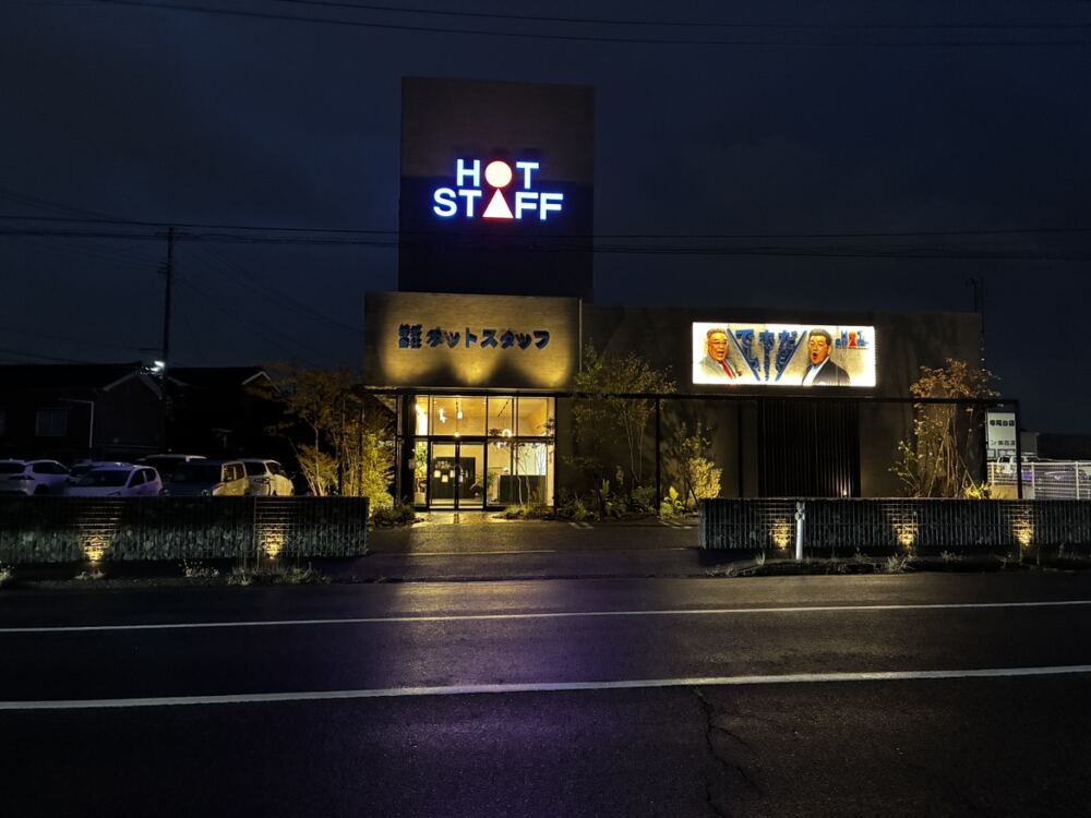 陽が落ちると、ファサードは昼の端正な表情からドラマチックな夜景へと一変します。
道路沿いのディアウォールには足元からスポットライトを当て、凹凸のある自然石の陰影を鮮やかに強調。
Gフレームの内側に植えた木々の枝影が照らし出されて外壁に美しく揺らめき、エントランス周りを温かく照らし出します。
夜間の視認性と防犯性を高めると同時に、夜の街路においてひときわ洗練された存在感を放つ景観を完成させました。