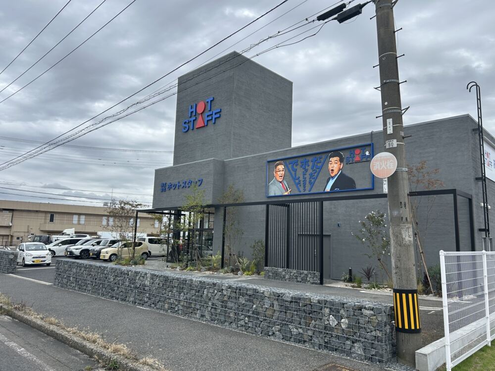 道路境界沿いに、自然石をメッシュフレームで包み込んだ長大なディアウォールを大胆に配置。
一新されたシックなグレーの外壁と見事に調和し、前面道路を行き交う車や歩行者の視線を引きつける、圧倒的な存在感と洗練された企業イメージを確立しました。
堅牢な石の質感が、オフィスのエントランスに確かな品格と重厚感をもたらしています。