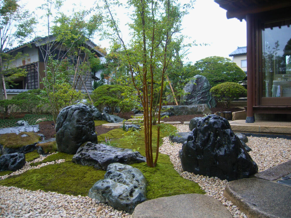 庭木を整理しながら銘石と苔を中心に構成し、白い砂利と飛び石を組み合わせることで、奥行きと静けさを感じられる枯山水の庭へと生まれ変わりました。